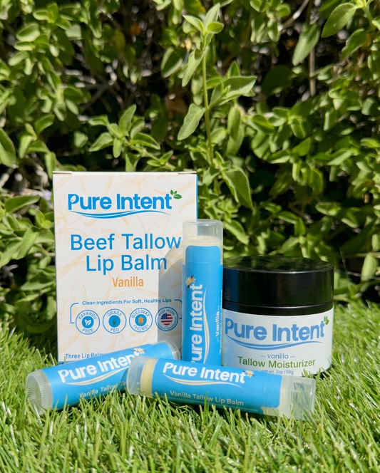 Pure Intent skincare products including lip balm and moisturizer on grass with greenery in the background