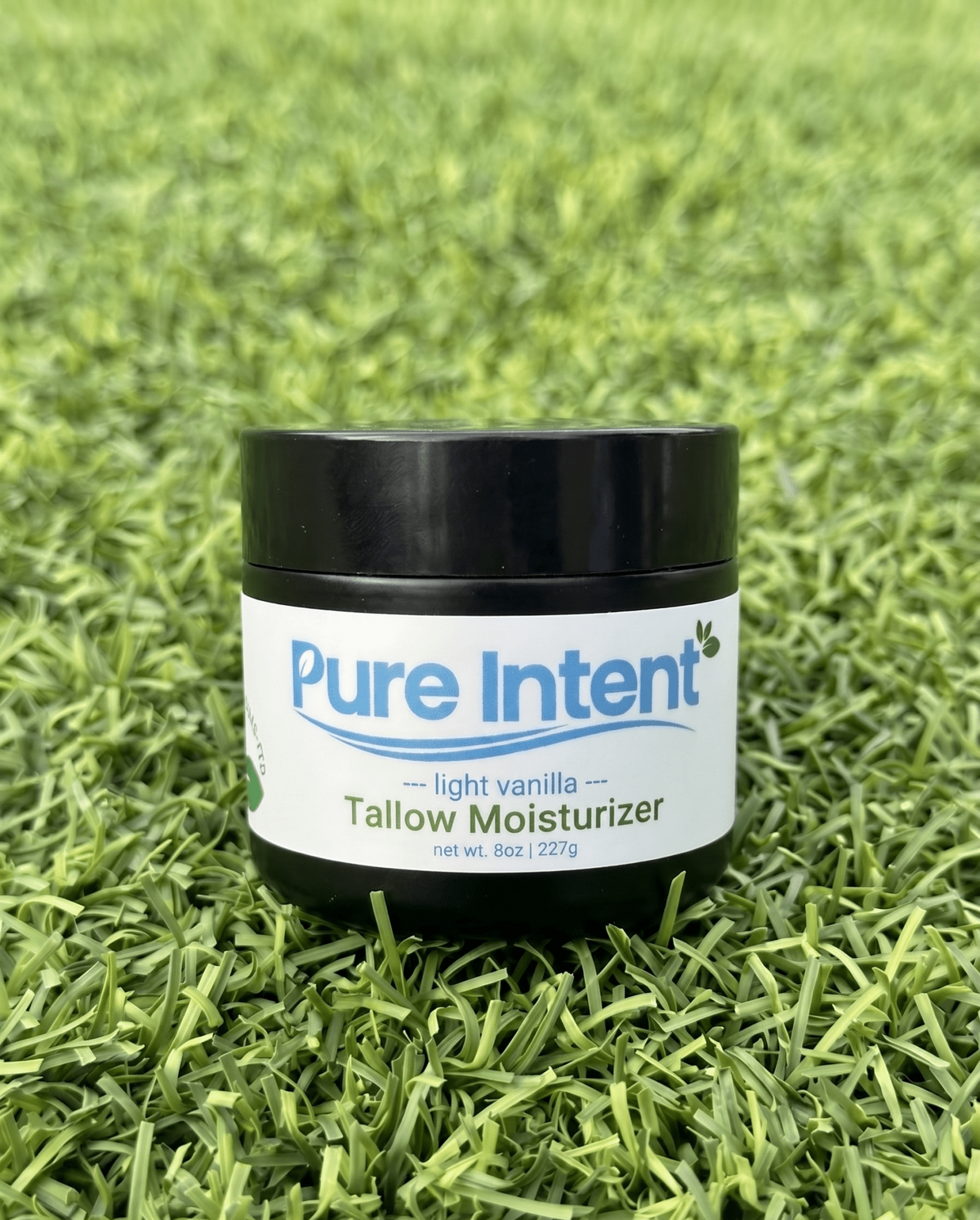 Jar of Pure Intent tallow moisturizer on grass