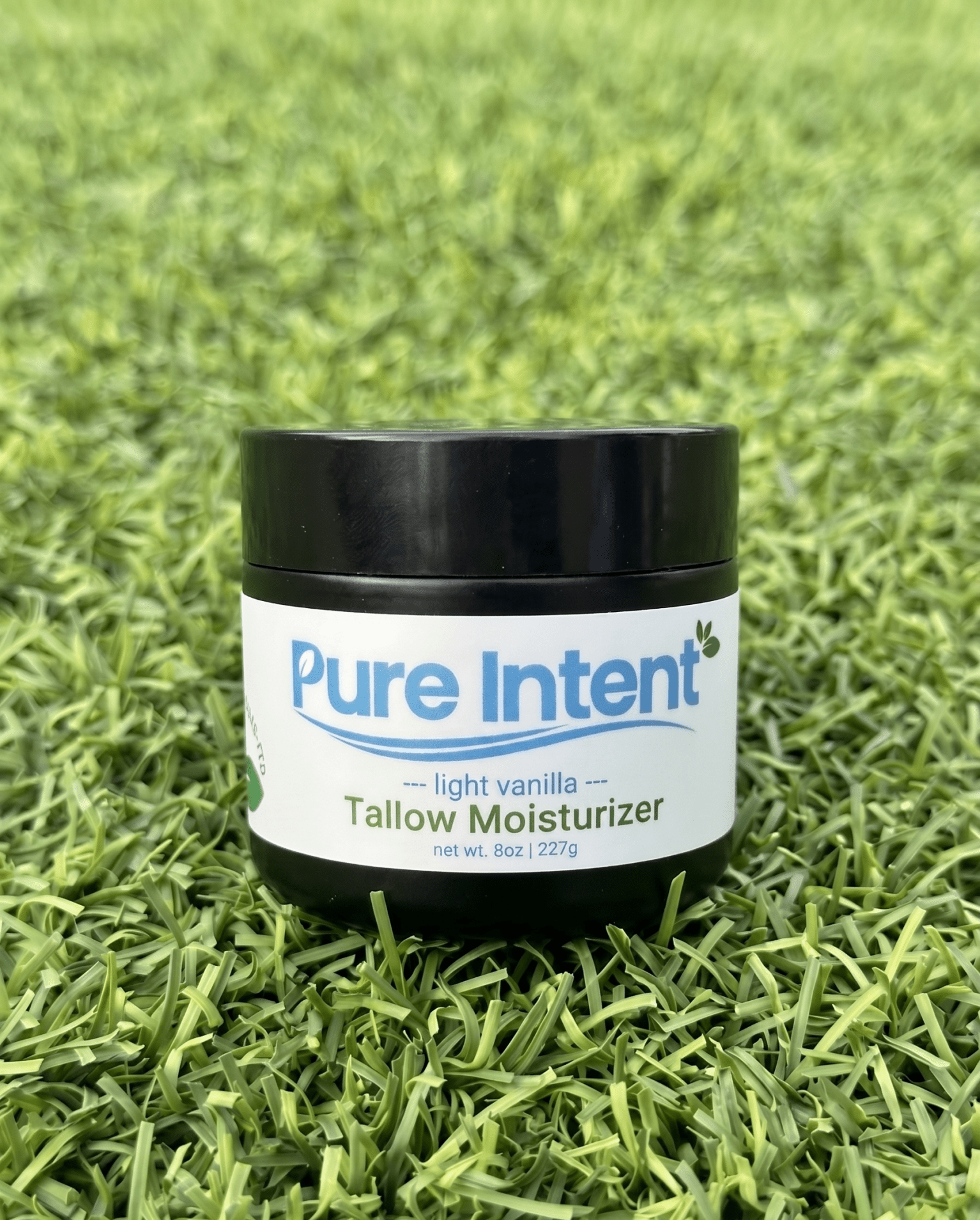 Jar of Pure Intent tallow moisturizer on grass