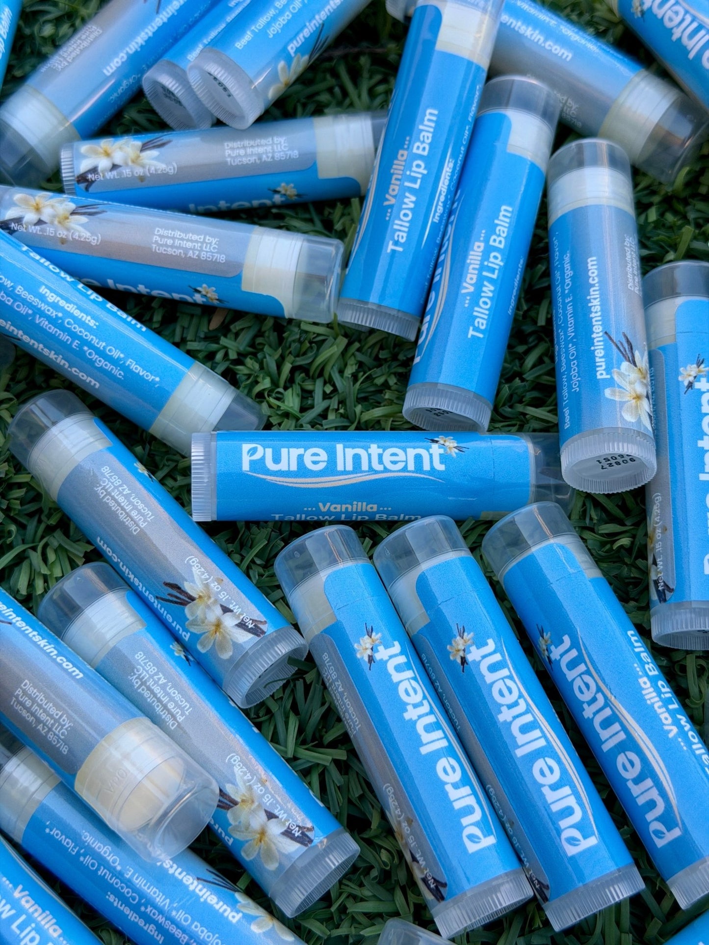 Multiple Pure Intent lip balms on grass
