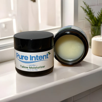 Pure Intent Vanilla Beef Tallow Moisturizer sitting on a bright window sill, a hydrating daily skincare essential.